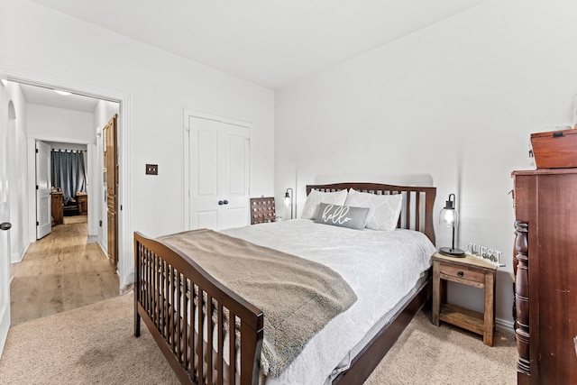 bedroom featuring a closet, wood finished floors, and baseboards