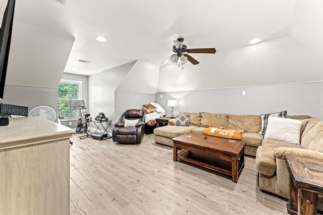living room with a ceiling fan, visible vents, vaulted ceiling, and light wood-type flooring