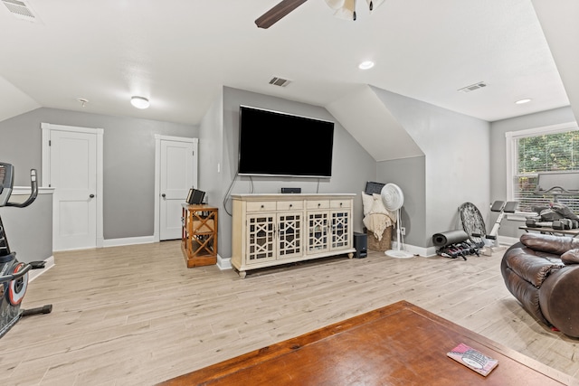 living area with lofted ceiling, a ceiling fan, visible vents, baseboards, and wood finished floors