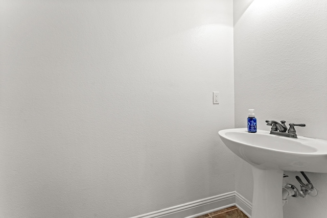bathroom featuring a sink and baseboards