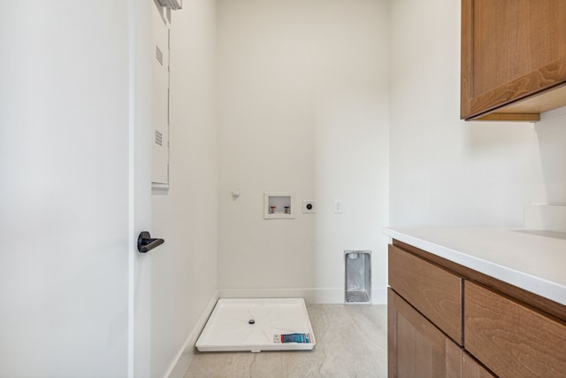 washroom with cabinet space, hookup for an electric dryer, hookup for a gas dryer, washer hookup, and baseboards