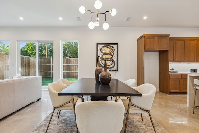 dining area with finished concrete flooring, an inviting chandelier, visible vents, and recessed lighting