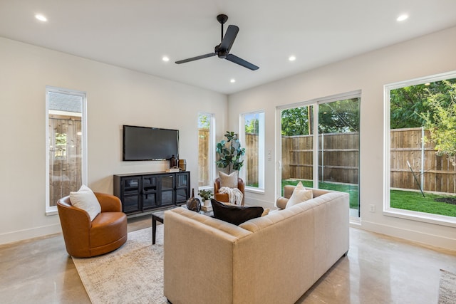 living room featuring concrete floors, recessed lighting, a ceiling fan, and baseboards