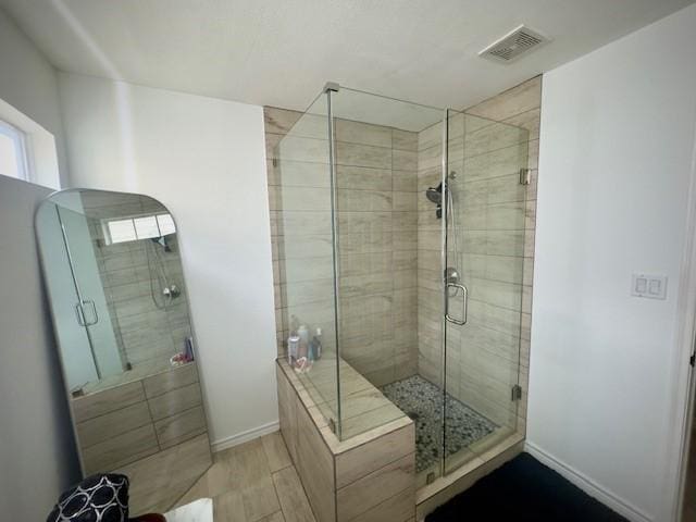 bathroom featuring baseboards, visible vents, and a stall shower