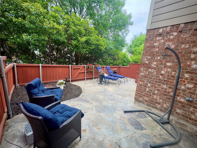 view of patio featuring a gate, an outdoor hangout area, and a fenced backyard