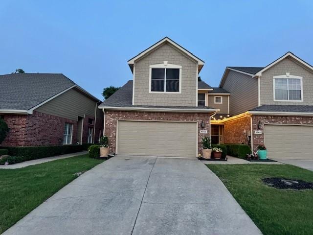 view of front facade with brick siding, a front lawn, concrete driveway, and an attached garage