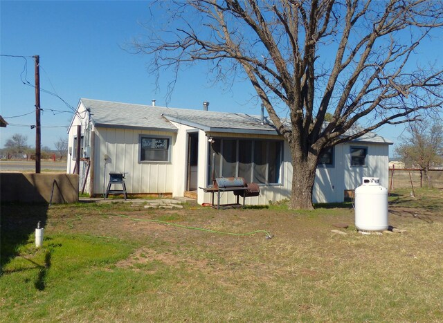 286 N Fm 1851, Voca, TX 76887 - rear view of house featuring board and batten siding, a shingled roof, and a lawn