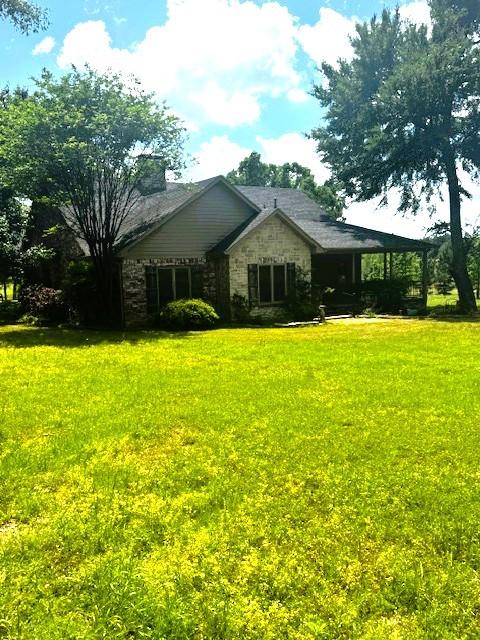 view of front of property featuring a front lawn and stone siding