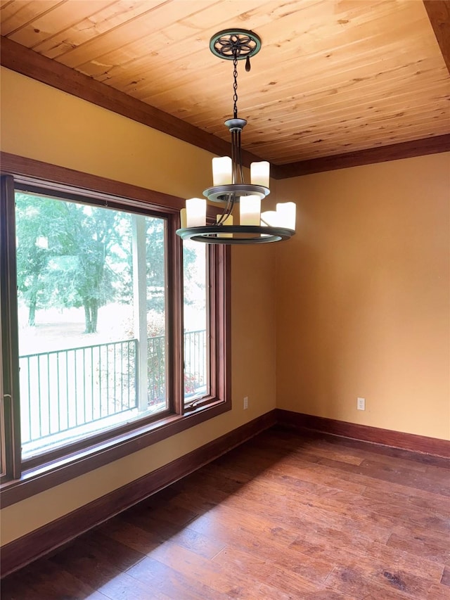 unfurnished dining area with wood ceiling, wood finished floors, baseboards, a notable chandelier, and ornamental molding