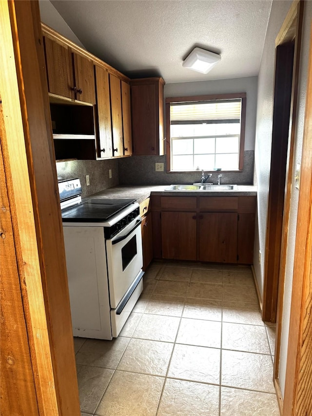 kitchen featuring backsplash, a textured ceiling, a sink, light tile patterned floors, and electric stove