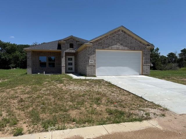 10185 Budtime Ln, Dallas, TX 75217 - view of front of house featuring an attached garage, driveway, and brick siding