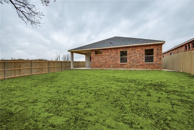 10185 Budtime Ln, Dallas, TX 75217 - rear view of house with a patio area, brick siding, and roof with shingles