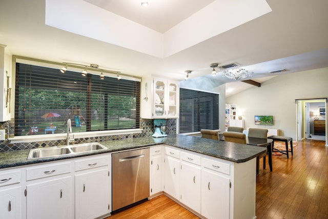 2403 Leslie St, Denton, TX 76205 - kitchen with stainless steel dishwasher, a sink, a peninsula, dark countertops, and decorative backsplash
