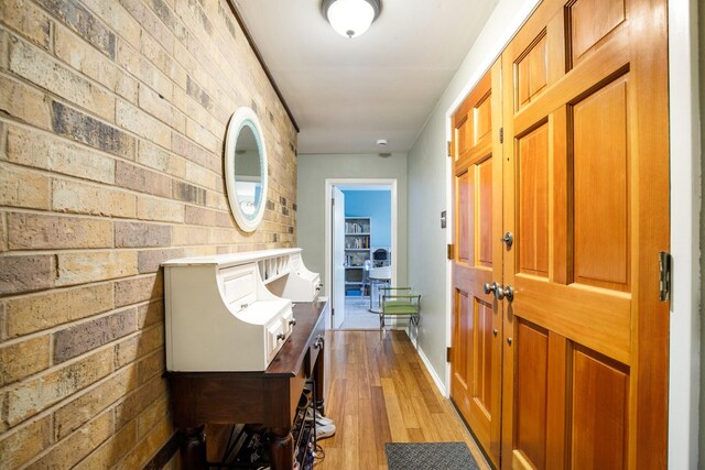2403 Leslie St, Denton, TX 76205 - hallway featuring brick wall, light wood-style floors, and baseboards