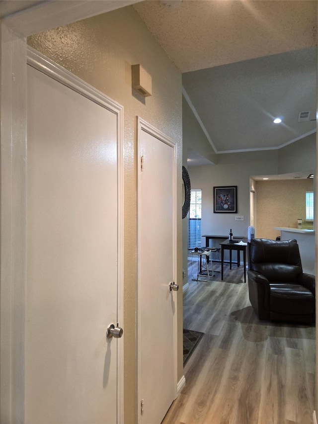 hallway with recessed lighting, visible vents, wood finished floors, and baseboards