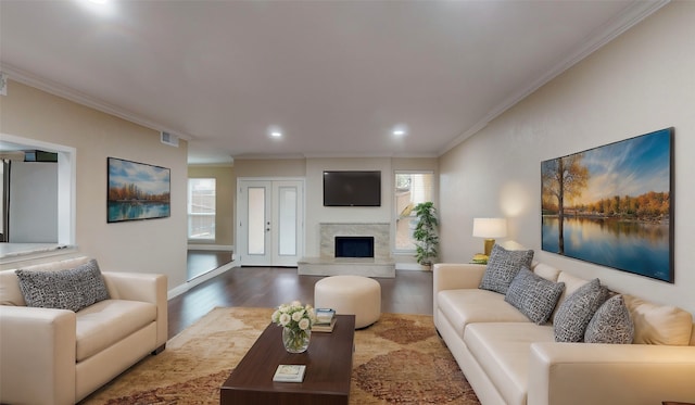 living area with recessed lighting, crown molding, visible vents, a high end fireplace, and wood finished floors