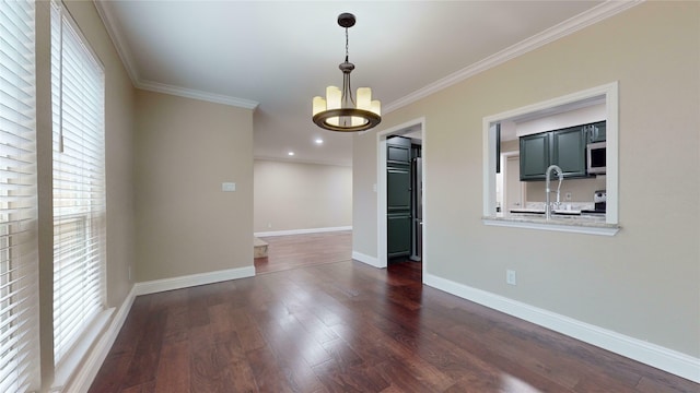 empty room featuring a chandelier, baseboards, ornamental molding, and dark wood-type flooring