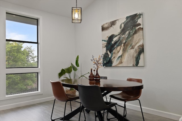 dining area with baseboards and wood finished floors