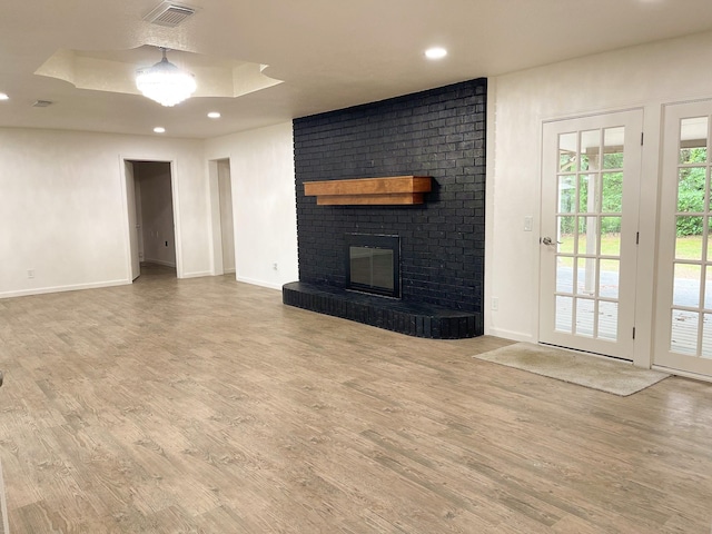 unfurnished living room with recessed lighting, visible vents, wood finished floors, and baseboards
