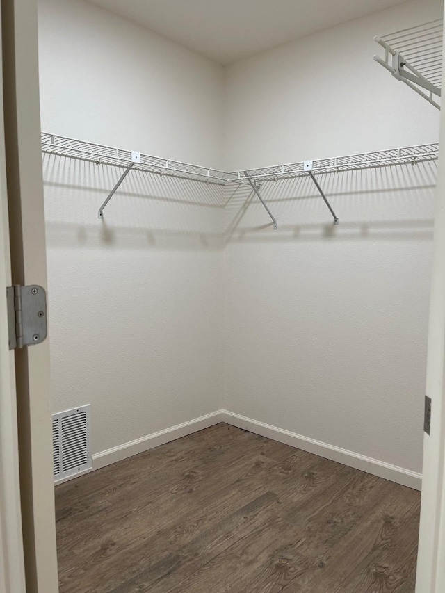 walk in closet with dark wood-style floors and visible vents