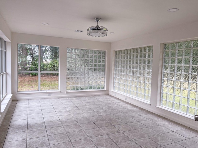 unfurnished sunroom featuring visible vents and plenty of natural light