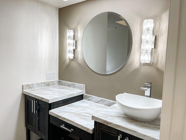 bathroom featuring a textured wall and vanity