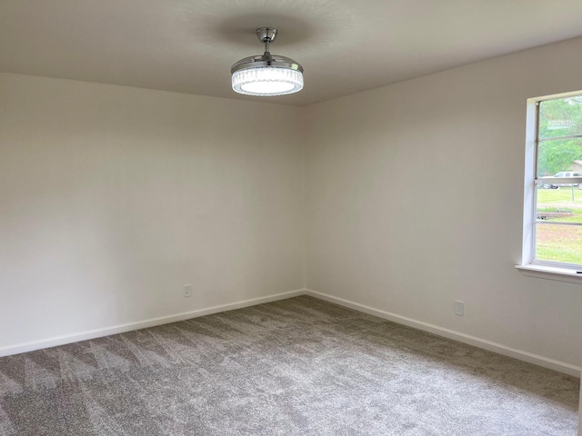 carpeted spare room featuring plenty of natural light and baseboards