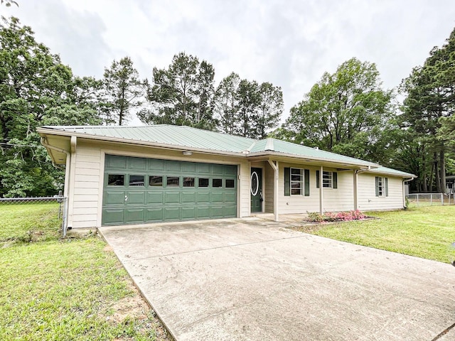 ranch-style house featuring driveway, metal roof, an attached garage, fence, and a front lawn