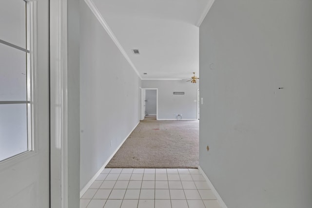 hallway with baseboards, visible vents, ornamental molding, and light colored carpet
