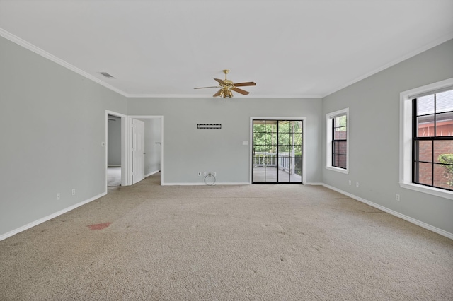 unfurnished room featuring a healthy amount of sunlight, ceiling fan, carpet flooring, and crown molding