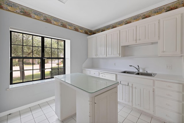kitchen featuring light tile patterned floors, a sink, light countertops, a center island, and baseboards
