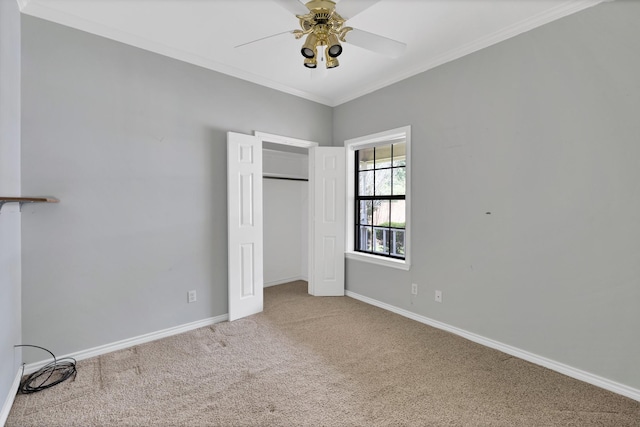 unfurnished bedroom with carpet floors, a closet, ornamental molding, ceiling fan, and baseboards