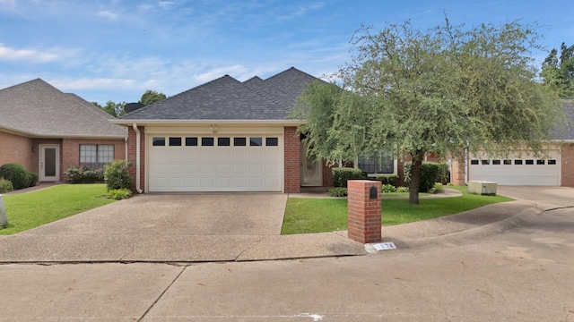 view of front of house featuring brick siding, roof with shingles, a front lawn, concrete driveway, and an attached garage