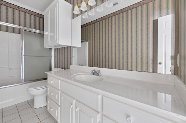 bathroom with vanity, bath / shower combo with glass door, toilet, tile patterned flooring, and wallpapered walls