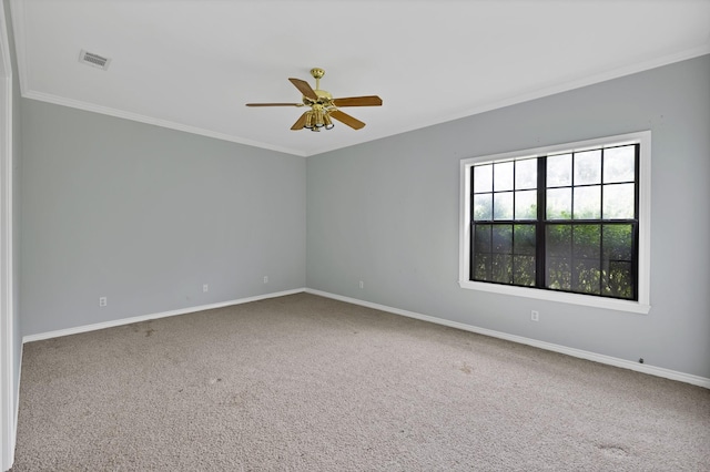 carpeted empty room featuring baseboards, visible vents, ceiling fan, and crown molding