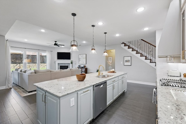 1146 Berrydale Dr, Northlake, TX 76226 - kitchen with dishwasher, a ceiling fan, a center island with sink, a fireplace, and dark wood-type flooring