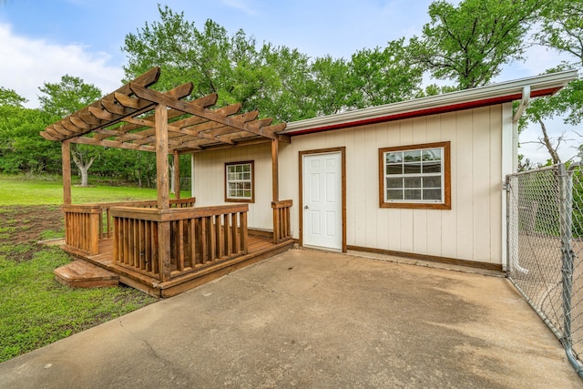 view of outdoor structure featuring fence and a pergola