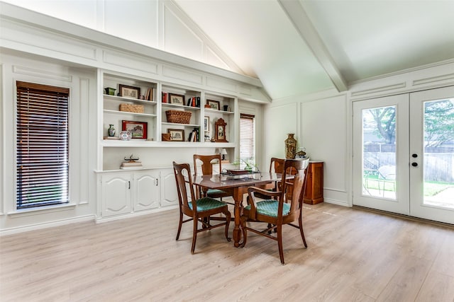dining room featuring a decorative wall, french doors, and light wood-style flooring