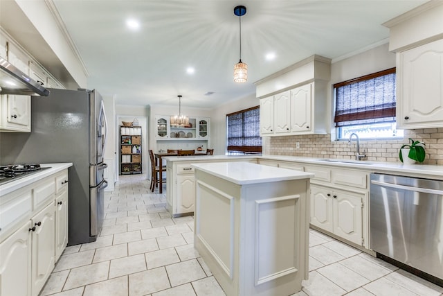 kitchen with stainless steel dishwasher, a sink, tasteful backsplash, a center island, and white cabinets