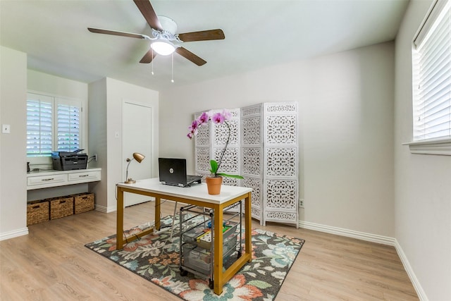 office space featuring ceiling fan, light wood-type flooring, and healthy amount of natural light