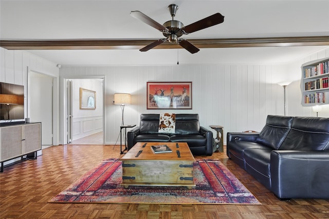 living room featuring a ceiling fan and a decorative wall