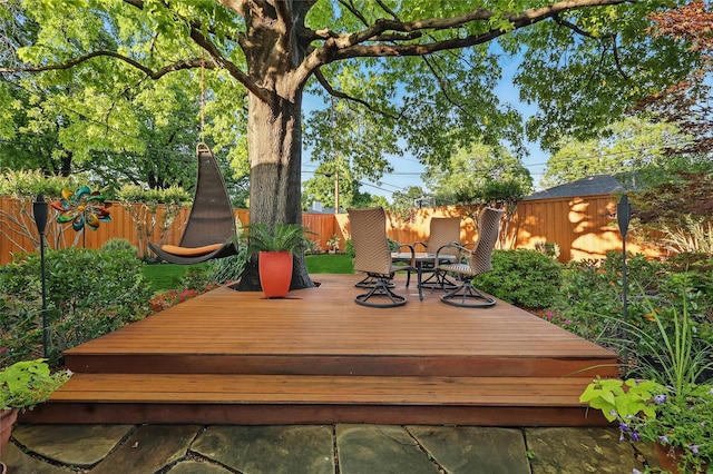 wooden terrace with a fenced backyard