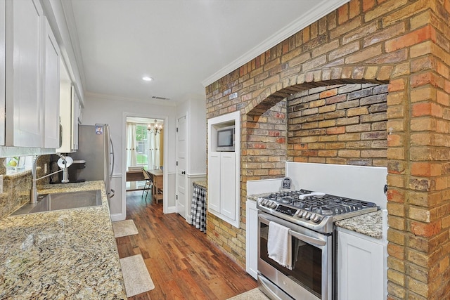 kitchen featuring crown molding, a sink, stainless steel range with gas stovetop, an inviting chandelier, and dark wood-style flooring