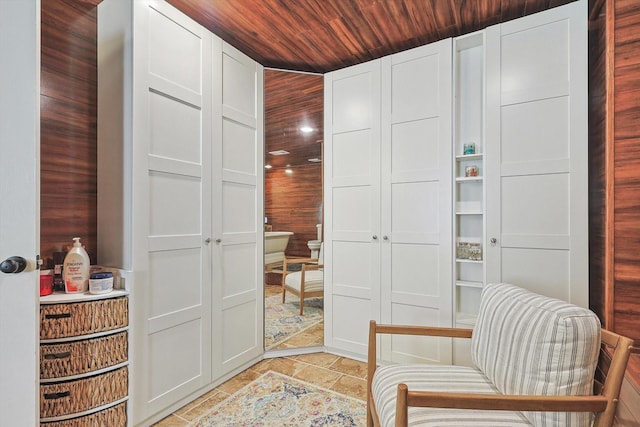 sitting room featuring wood ceiling and stone finish flooring