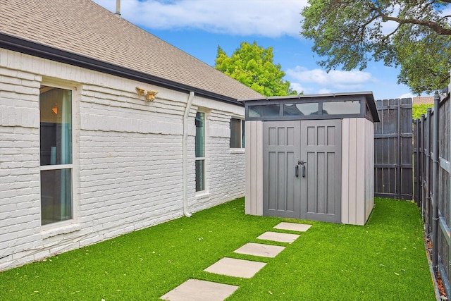 view of yard with an outbuilding, a storage unit, and fence private yard