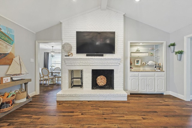 living area with baseboards, vaulted ceiling, wood finished floors, and a fireplace