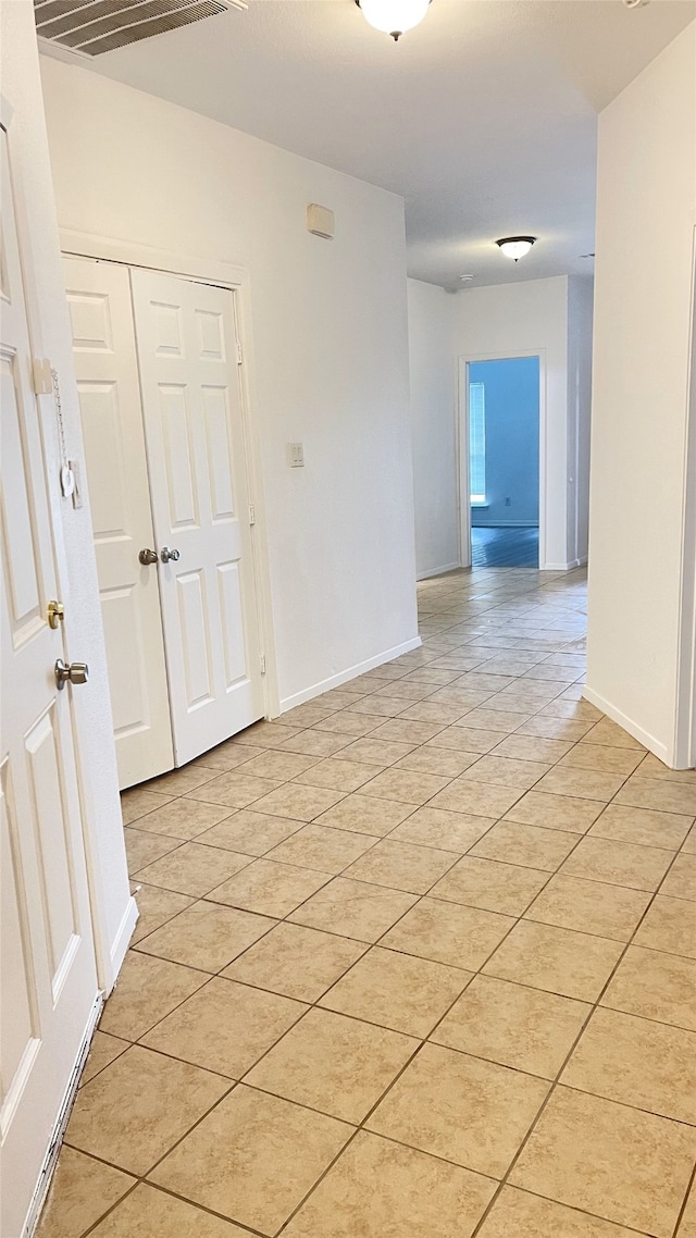 empty room with light tile patterned floors and baseboards
