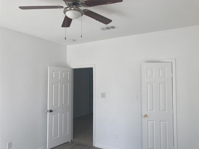 unfurnished bedroom with dark wood finished floors, visible vents, a ceiling fan, and baseboards