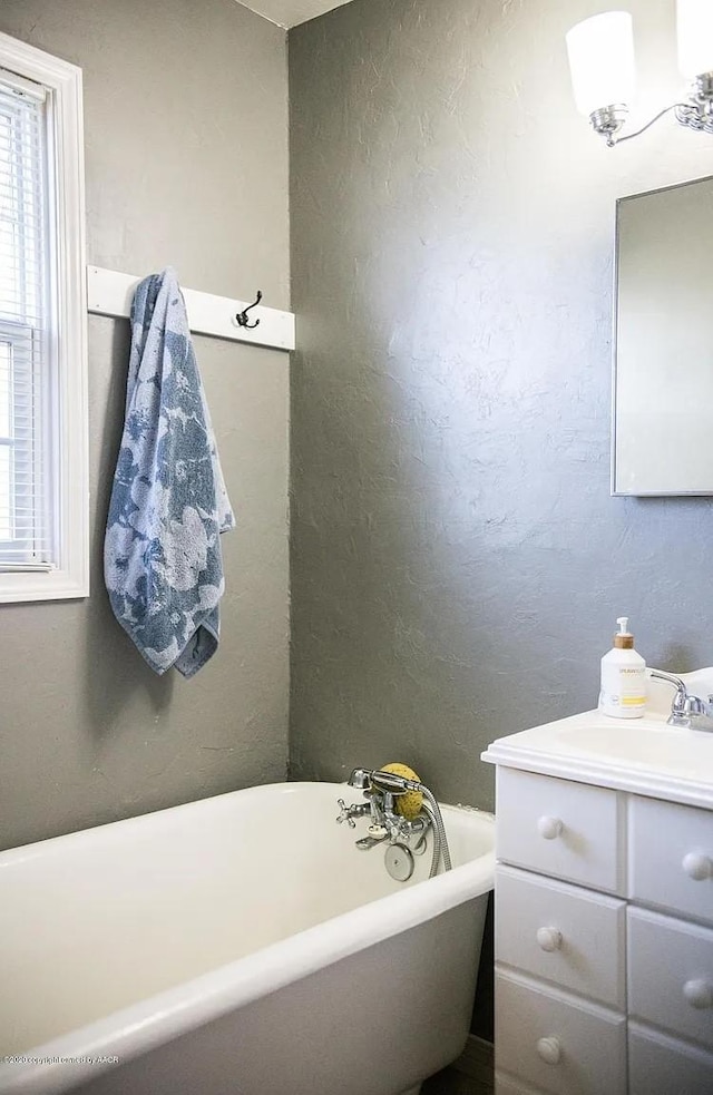 509 W 3rd St, Claude, TX 79019 - bathroom with a textured wall, vanity, and a freestanding bath