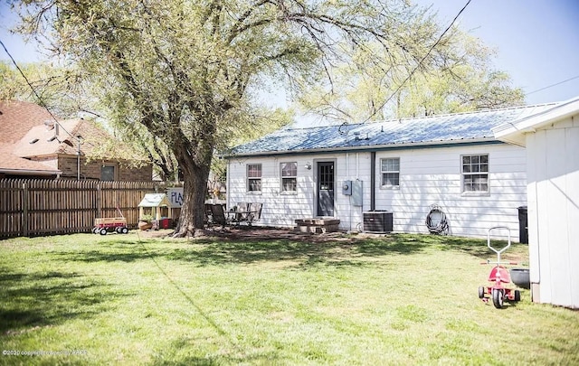 509 W 3rd St, Claude, TX 79019 - rear view of property featuring cooling unit, a yard, metal roof, and fence